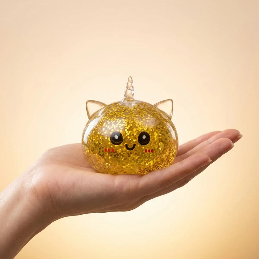 Gold unicorn dumpling squishy held in hand for size