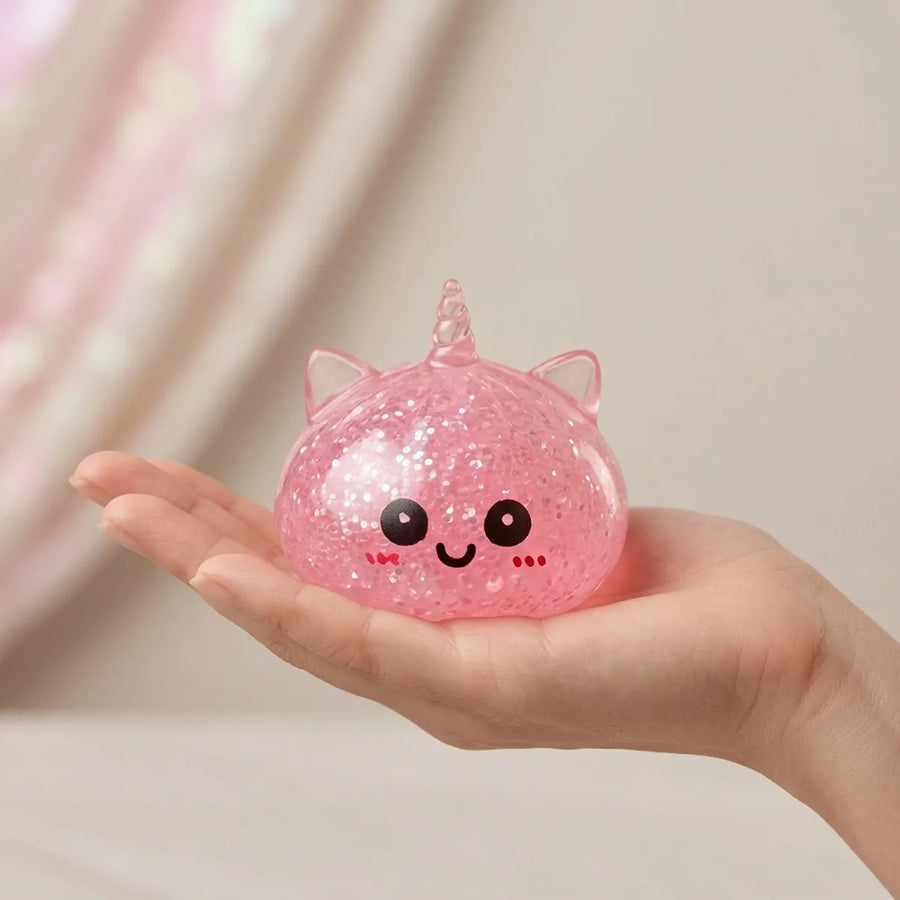 Pink unicorn dumpling squishy held in hand for size